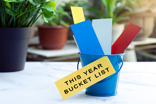 Colorful paper inside of a blue bucket with this year bucket list label. Bucket list concept.