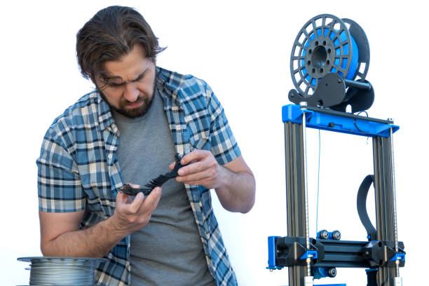 istock Man looking at supports resulting from a 3D print. 1840533313