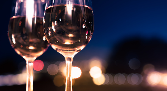 Wineglasses against a city lights at night.