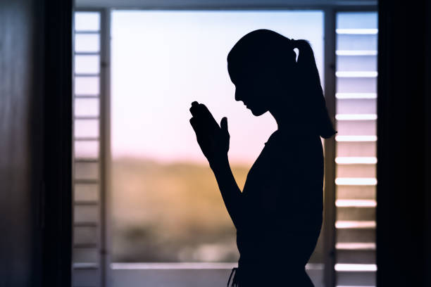 istock Woman praying  at home. 1840551240