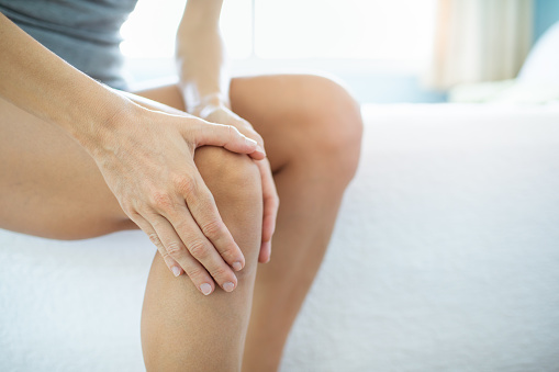 Woman holding her knee. Pain.