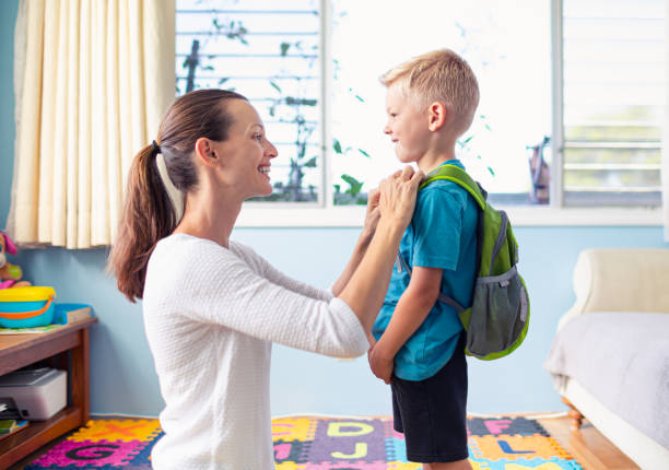 istock Mother helping get ready her son to school. First day at school. 1840552317