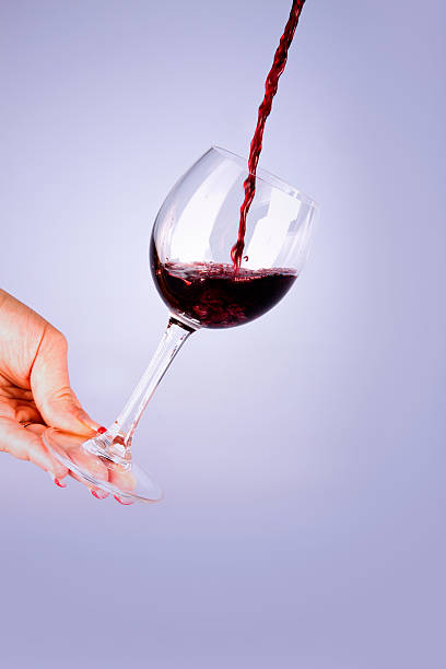 istock Red wine with glass in hands 184055240