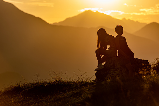 Silhouette of Mother and Daughter at the Sunset in Mountain