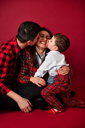 Father And Son Kissing Mother While Celebrating Christmas Together