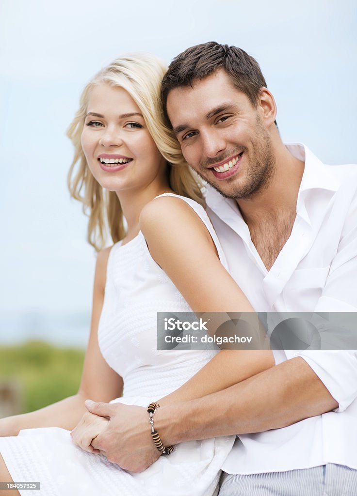 couple in shades at sea side summer holidays and dating concept - couple in shades sitting at sea side Wedding Stock Photo