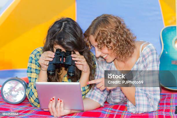 Photo libre de droit de Deux Jeunes Femmes Faire Du Camping De La Rivière Lecture Sur Tablette Numérique banque d'images et plus d'images libres de droit de Activité de loisirs