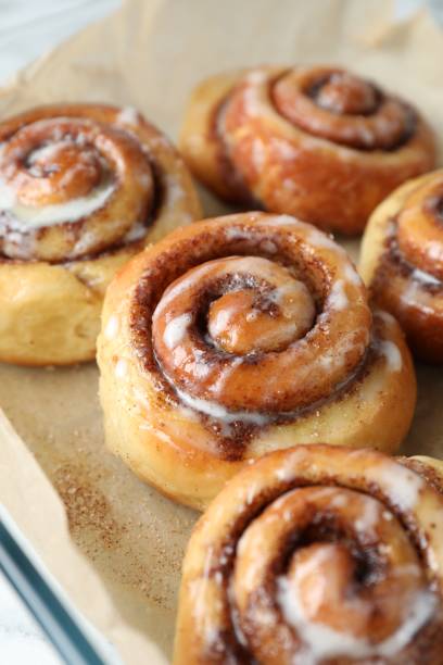 istock Baking dish with tasty cinnamon rolls on white table, closeup 1840591245