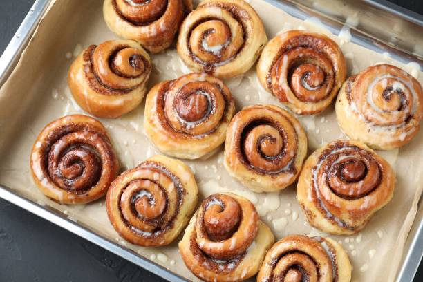 istock Baking dish with tasty cinnamon rolls on dark table, top view 1840593956