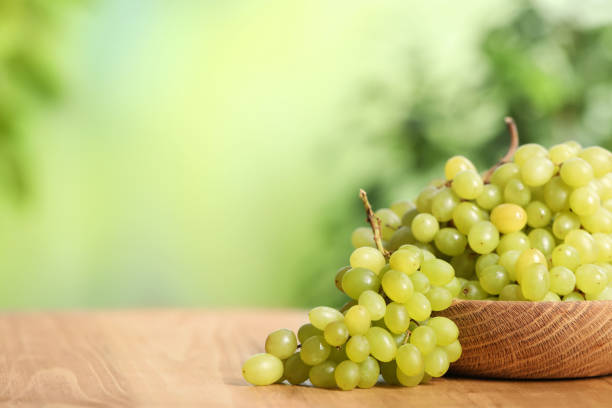 Delicious fresh green grapes on wooden table. Space for text