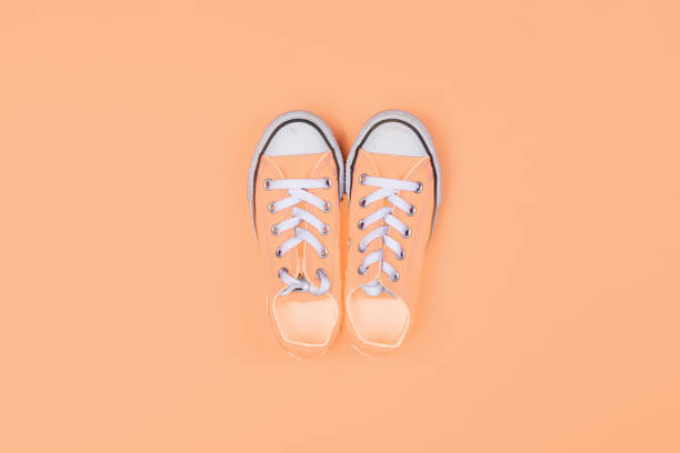 istock Sneakers top view on peach color color background 1840623947