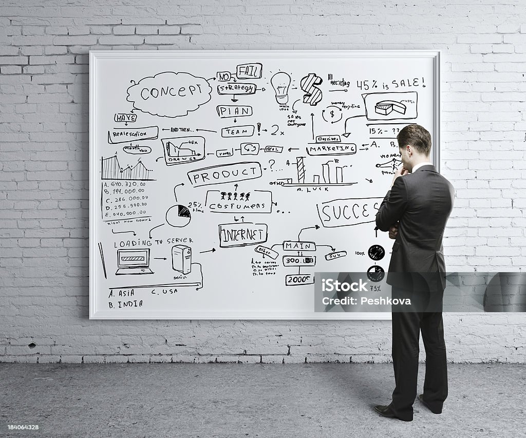 business strategy poster man looking at business strategy on board Adult Stock Photo