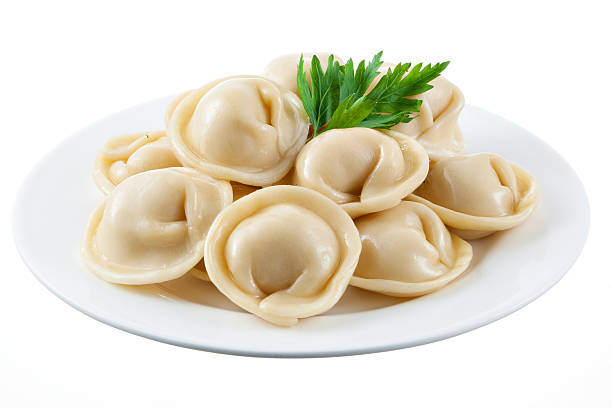 Dumplings with parsley isolated Dumplings and parsley - russian pelmeni - italian ravioli - on white plate isolated russian pelmeni stock pictures, royalty-free photos & images