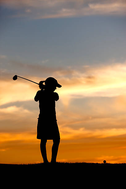 istock Silhouetted girl swings driver. 184066902