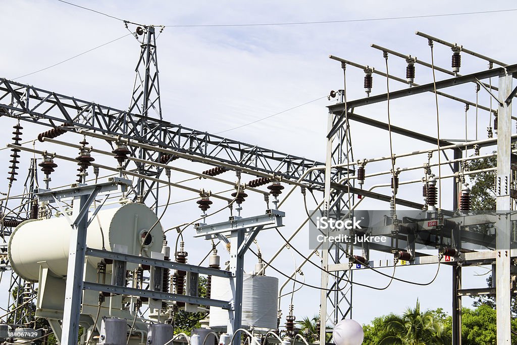 Stazione di energia elettrica con poli cavi e trasformatori di potenza - Foto stock royalty-free di Alta tensione