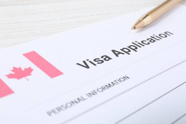istock Immigration to Canada. Visa application form and pen on white wooden table, closeup 1840692265