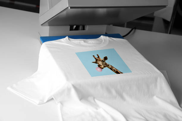 camiseta personalizada. uso de la prensa de calor para imprimir la imagen de la jirafa soplando chicle - printout industry store workshop fotografías e imágenes de stock