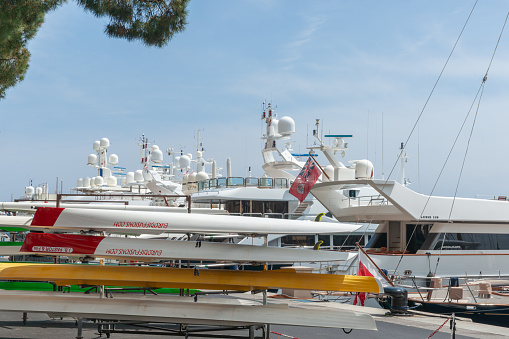 Monaco May 2 2011;  luxury boats moored beyond rowing skiffs on rack on wharf