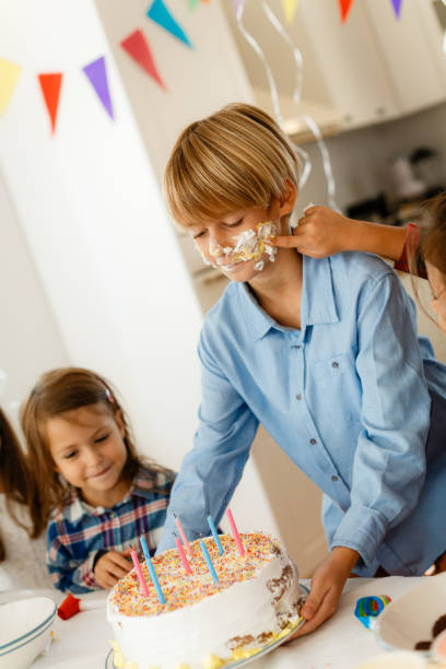 istock Children having fun putting icing on a Birthday boy’s face 1840739400