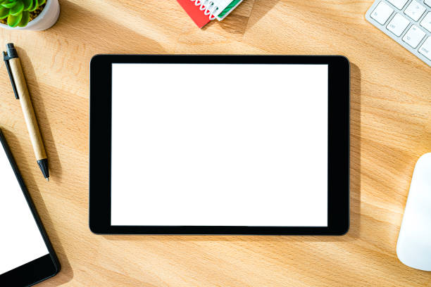 Overhead view of digital tablet with blank screen on wood desk