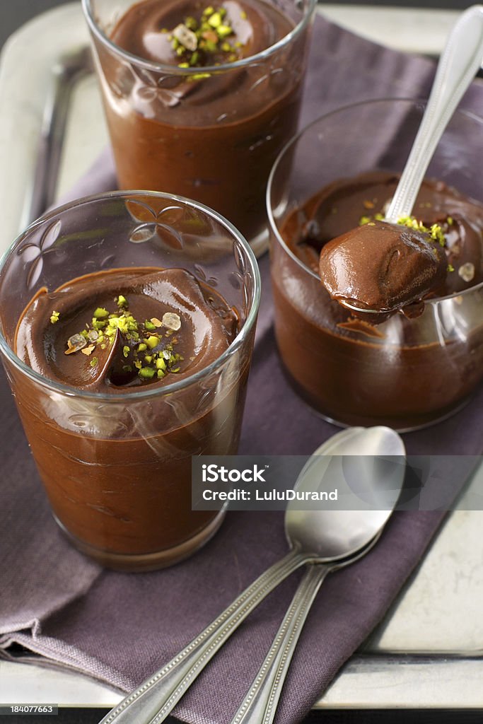 Chocolate avocado pudding Three servings of vegan chocolate avocado pudding in small tumblers, sprinkled with chopped pistachio and coarse sea salt, served on a rectangle metal tray lined with a purple napkin Chocolate Stock Photo