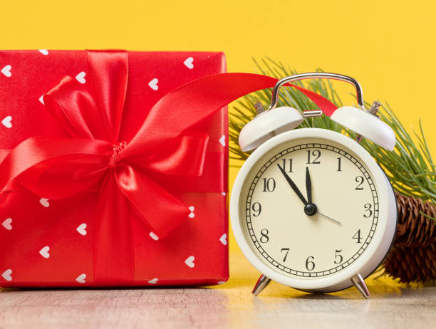 istock Alarm clock and stack of red gift boxes on yellow background 1840813187