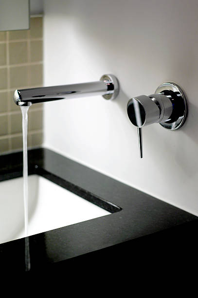 istock Modern style bathroom faucet running into sink 184084364