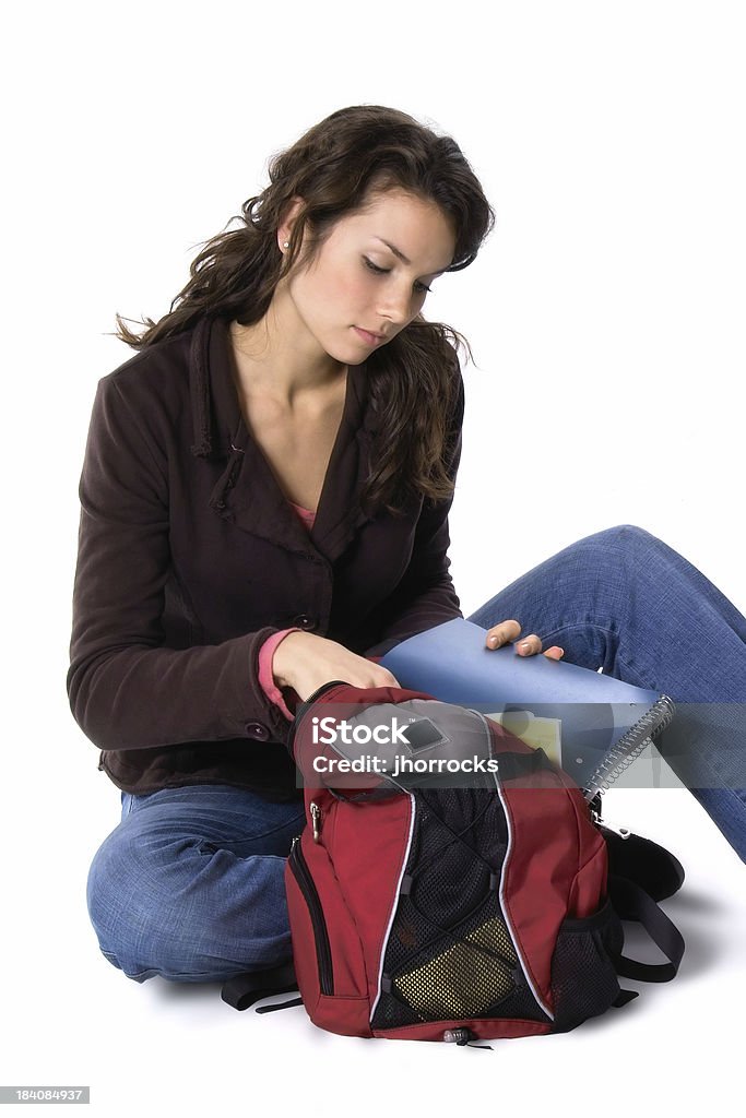 Packing Up Photo of a student putting a notebook in her backpack. Back to School Stock Photo