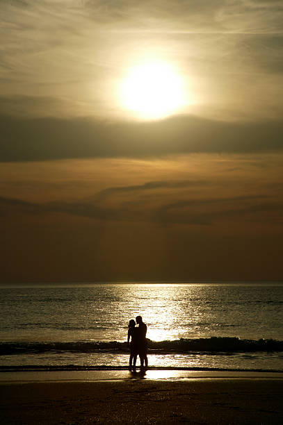 istock couple at sunset on beach 184085128