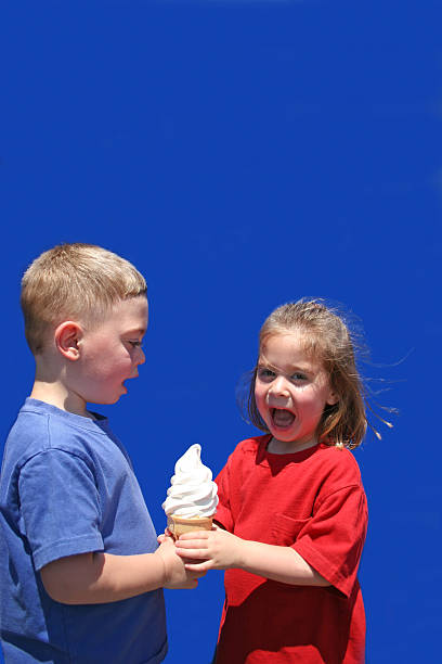 I Scream For Ice Cream Young girl screaming and taking young boy's ice cream cone away stealing ice cream stock pictures, royalty-free photos & images