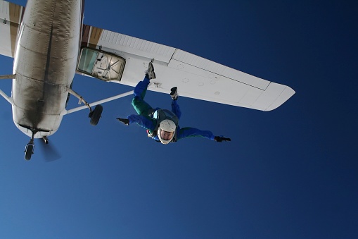 Skydiver exiting a small airplane