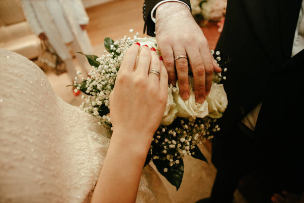 istock Couples hands with ring and wedding bouquet stock photo 1840861143