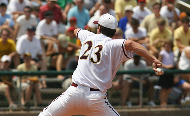 istock Adult baseball pitcher with spectators in background 184086302