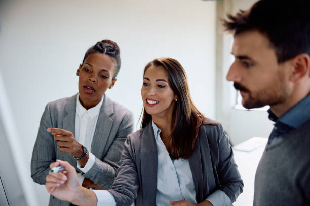 istock Group of entrepreneurs brainstorming while writing on whiteboard in the office. 1840863652