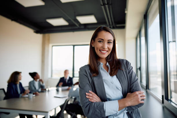 istock Young successful businesswoman at corporate office looking at camera. 1840864749