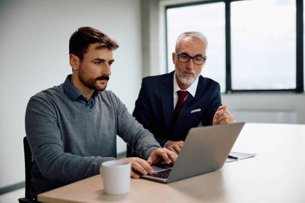 istock Businessmen cooperating while working on laptop in the office. 1840869394