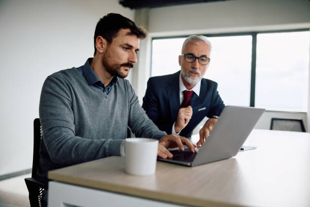 istock Businessman and his mature colleague using laptop while working in the office 1840869404