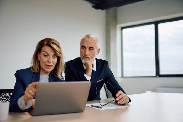 istock Female CEO and her coworker using laptop while working in the office. 1840869407