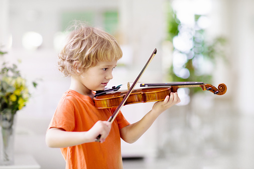 Child playing violin. Remote learning from home. Arts for kids. Little boy with musical instrument. Video chat conference lesson. Online music tuition. Creative children play song. Classical education