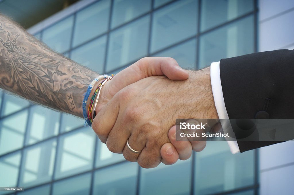 Aperto de mão entre Empresário e tattooed bad boy - Foto de stock de Acordo royalty-free