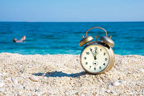 Alarm clock on beautiful sunny beach