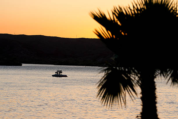 A wakeboard boat on Lake Havasu at sunset.