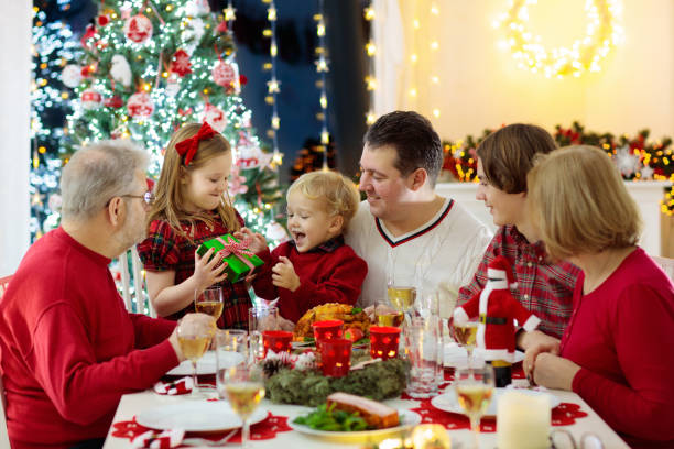 istock Family with kids having Christmas dinner at tree 1840876749