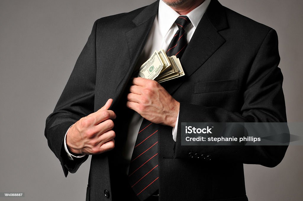 Бизнесмен соскальзывания с стека наличных в своем кармане костюм - Стоковые фото Валюта роялти-фри