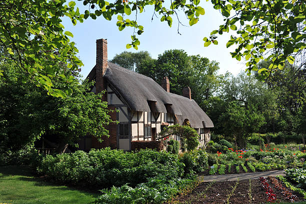 Ann Hathaway's Cottage "Anne Hathaway's Cottage is the 15th century former home of Anne Hathaway, the wife of William Shakespeare. The house is situated in village of Shottery, Warwickshire, England, and about 1 mile (1.6 km) west of Stratford-upon-Avon." thatched roof stock pictures, royalty-free photos & images