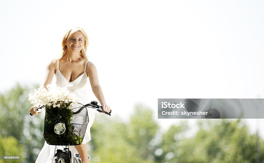 Linda loira sorridente em uma bicicleta. - Foto de stock de Adulto royalty-free