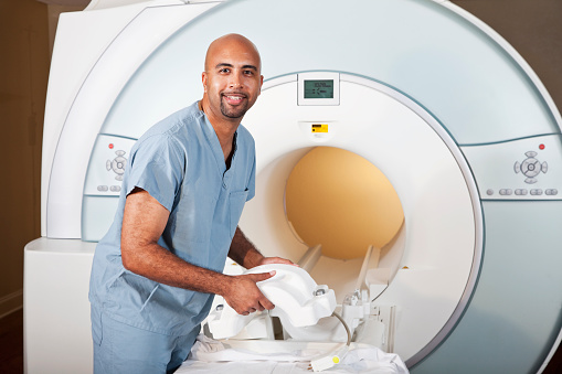 Healthcare worker, 40s, preparing MRI scanner