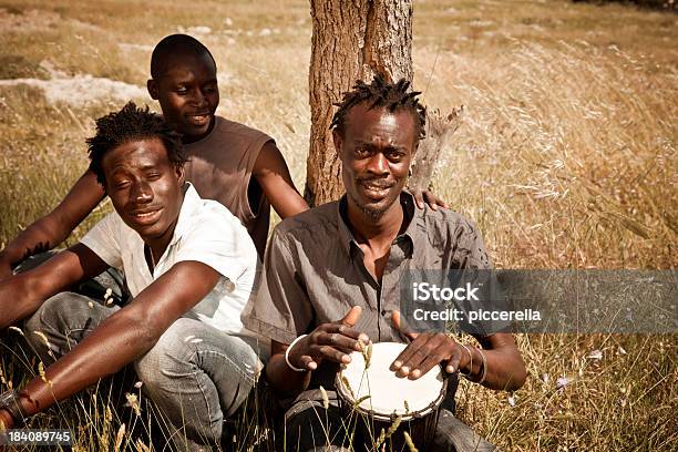 Foto de Três Africanos Homens Jogando Djembe No Meadow e mais fotos de stock de Origem Africana - Origem Africana, Cantar, Árvore