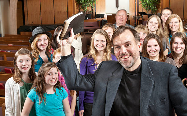 istock Pastor holding Bible with His People Behind 184090606