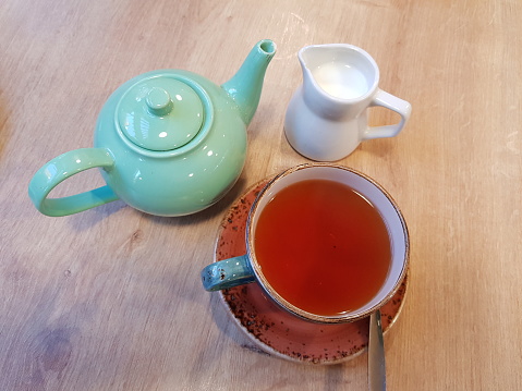 Hot tea being poured from a teapot into a tea cup